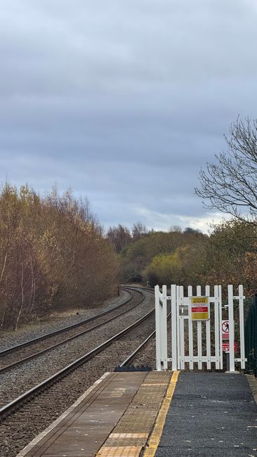 At Foots Cray railway station, the image shows an empty platform with a concrete edge and tactile paving near the edge for safety. The platform is adjacent to railway tracks extending into the distanc